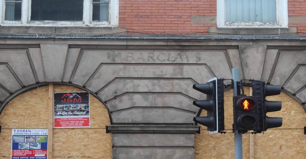 A closed down Barclays Bank building featuring a traditional facade and prominent entrance.