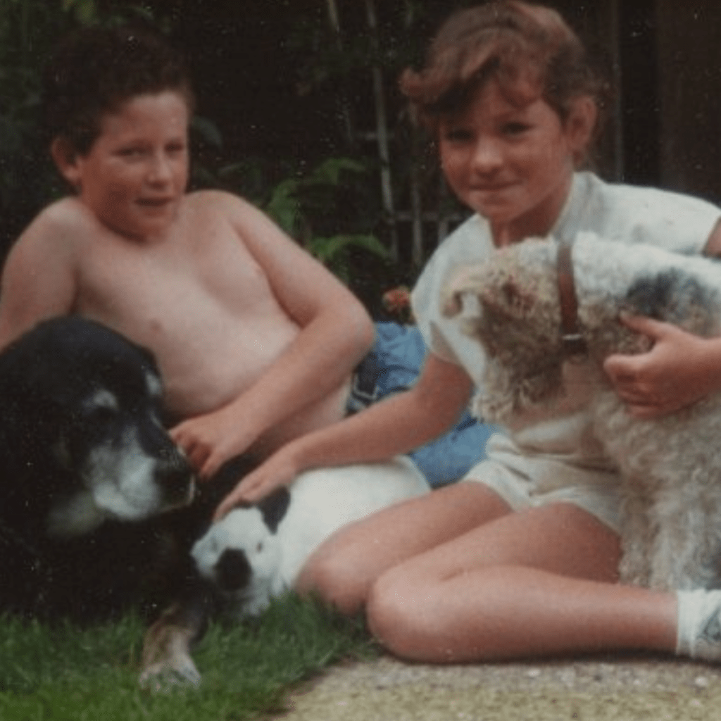 Alison Little around the age of 7 with dogs and brother.
