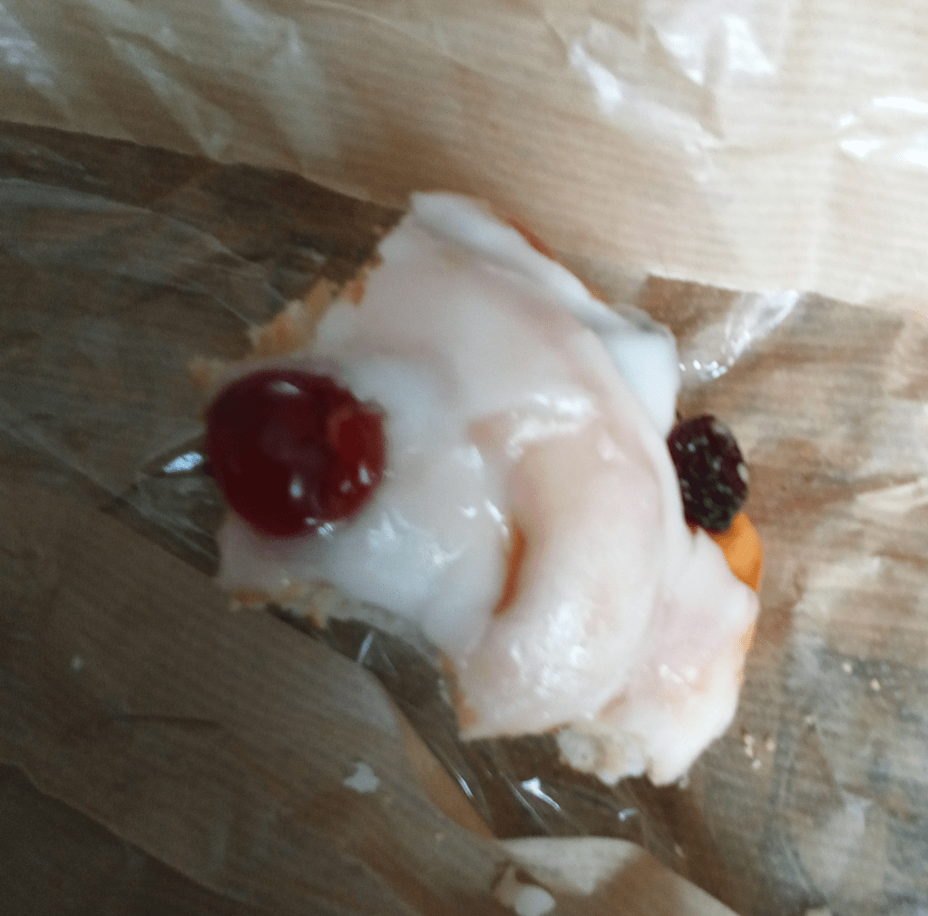 Photography of a nearly eaten Danish Pastry.