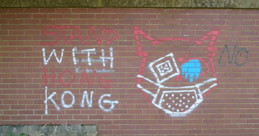 Red brick wall in Everton Park, Liverpool with a COVID style graffiti of a cat wearing a face mask.