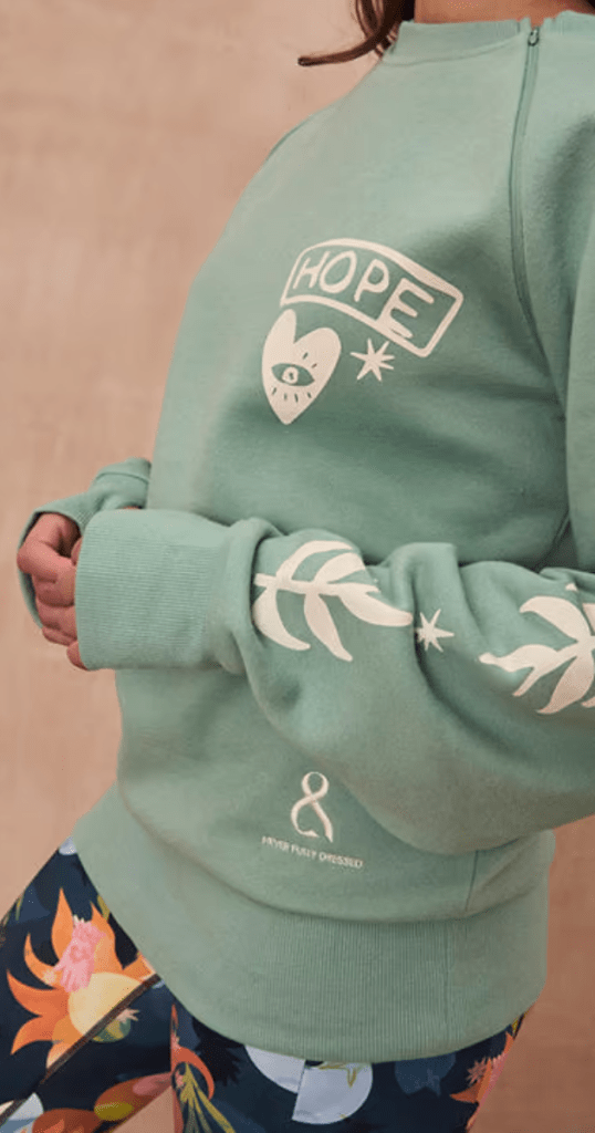 A woman dressed in a green sweatshirt that has the word "hope" written on it, symbolising positivity and encouragement.