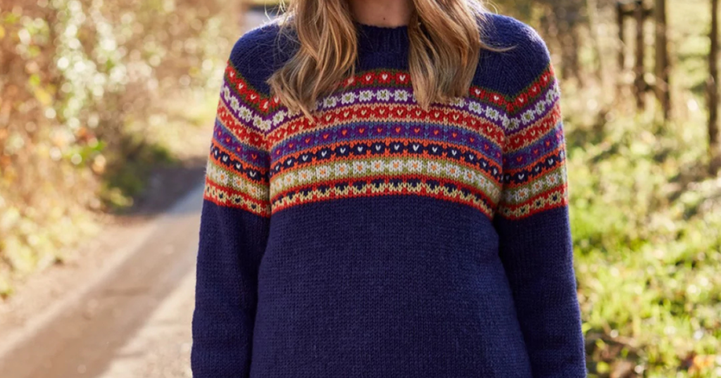 A woman dressed in a jumper adorned with bright, colourful patterns, highlighting her unique style.