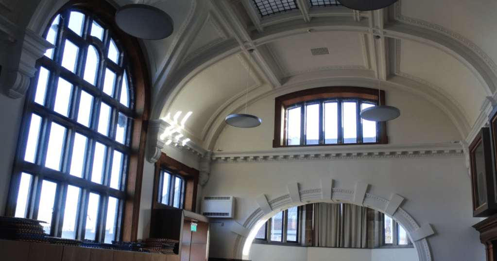 Interior of The Old Library with vaulted ceiling, ornate moulding, arched windows, and a blend of classical and modern architectural elements.
