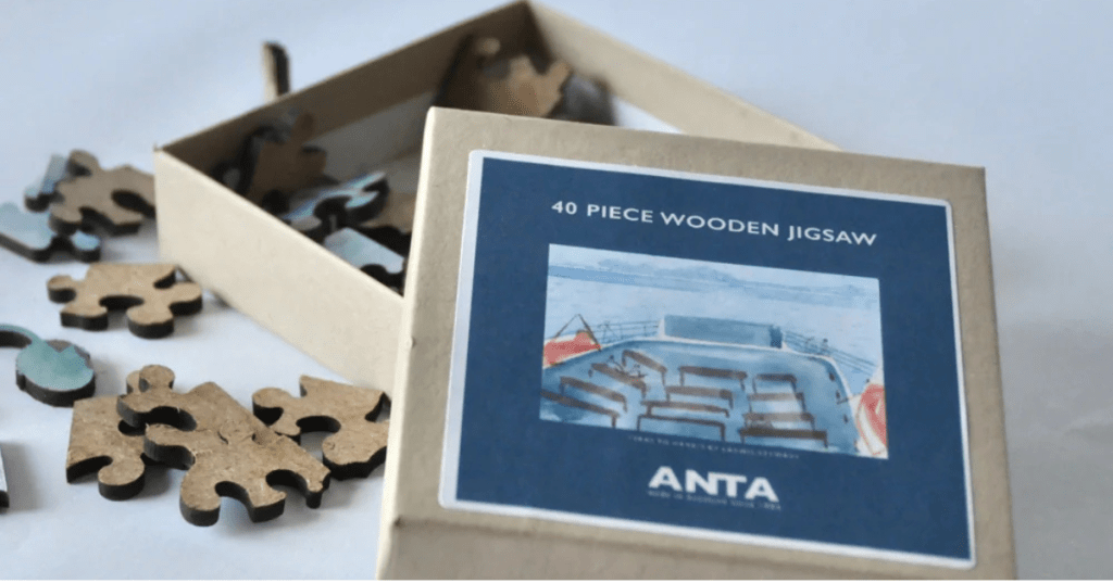 40-piece wooden jigsaw puzzle by ANTA, handcrafted in Scotland. Box features a scenic boat deck image; puzzle pieces shown with rich wood texture and artisanal finish—perfect for heritage gifts and mindful play