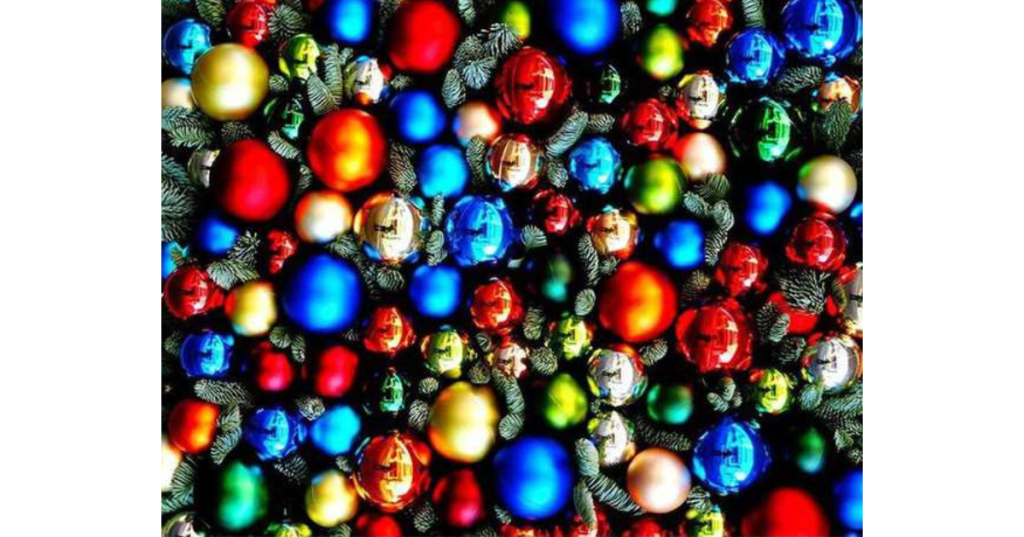 Christmas-themed jigsaw puzzle featuring colourful baubles in red, gold, blue, green, and silver nestled among pine branches. Reflective ornaments and vibrant holiday palette evoke festive cheer—perfect for seasonal gifting and cosy winter puzzling.