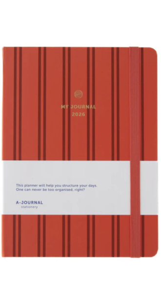 Red 2026 journal with vertical black stripes, gold foil title, and pink elastic closure. Features a white promotional band with motivational text and A-Journal branding. Stylish and functional planner for daily organization, ideal for students, professionals, or gift-giving.
