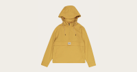 Mustard yellow hooded anorak with half-zip front, beige drawstring cords, and black-tipped ends. Features a front flap pocket with side openings and a small "FOM" patch. Lightweight and functional design ideal for casual wear or light outdoor activities.