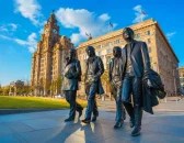 Bronze statue of The Beatles in Liverpool City Centre, with the Royal Liver Building in the background—featured stop on Liverpool City Centre Walking Tour celebrating music history and iconic landmarks.