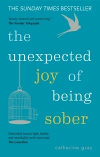 Book cover for The Unexpected Joy of Being Sober by Catherine Gray. Features a teal background with the title in bold white and yellow lettering, an open birdcage hanging from the top left, and a small bird flying free in the top right. Includes review quotes and bestseller note. Clean, uplifting design aimed at readers interested in sobriety, wellbeing, and personal transformation.