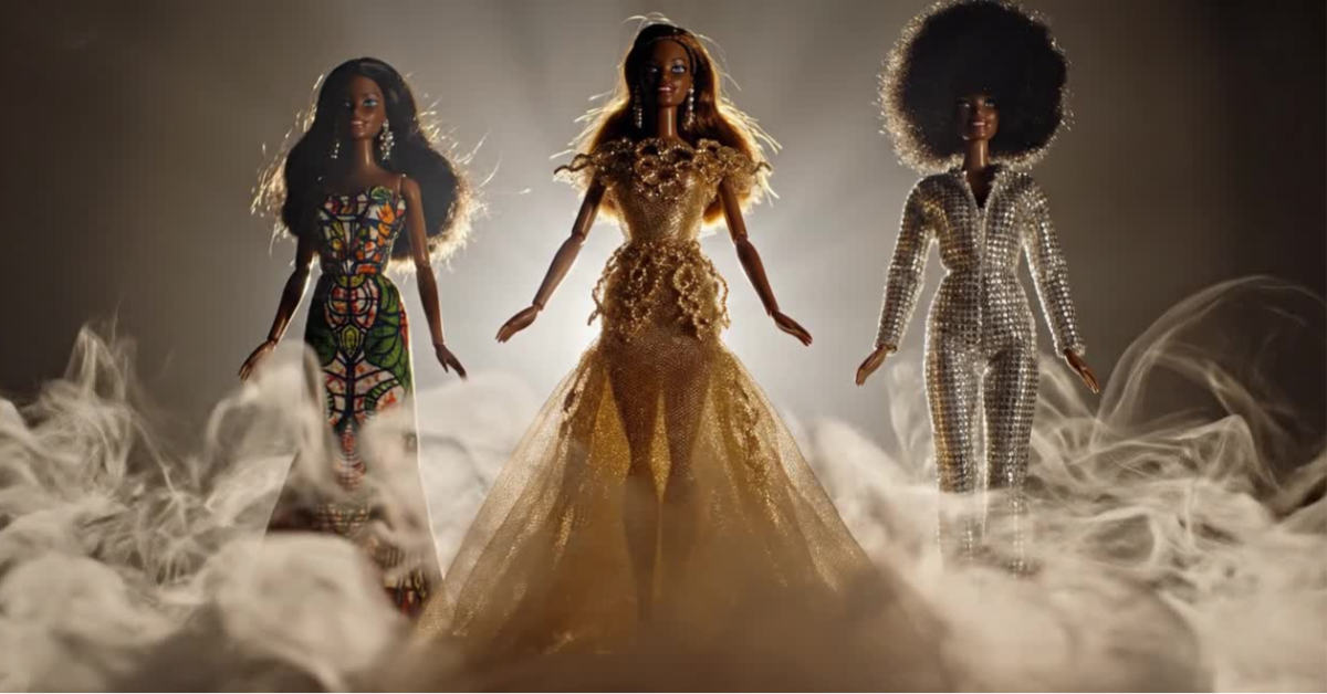 Three fashion dolls stand side by side in bright backlighting and drifting haze, each wearing a distinct outfit — a patterned dress, an ornate gold gown, and a silver sequin jumpsuit with an afro hairstyle. The atmospheric scene visually echoes the line ‘Black Barbies in a haze’ from the poem Spiced to Vices.